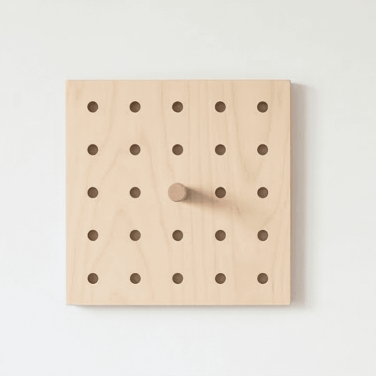 Square birch plywood pegboard with wooden peg mounted on wall